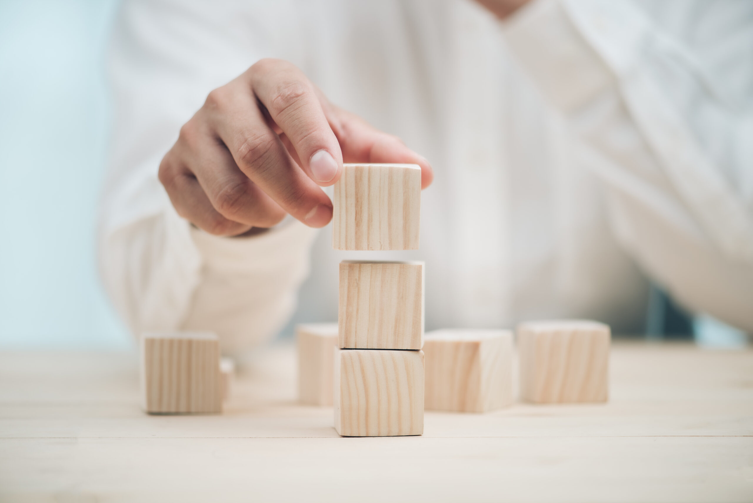 Hand arranging three wood cube stacking. Business concept growth success,hand stack woods block step on table. business development concept.copy space.